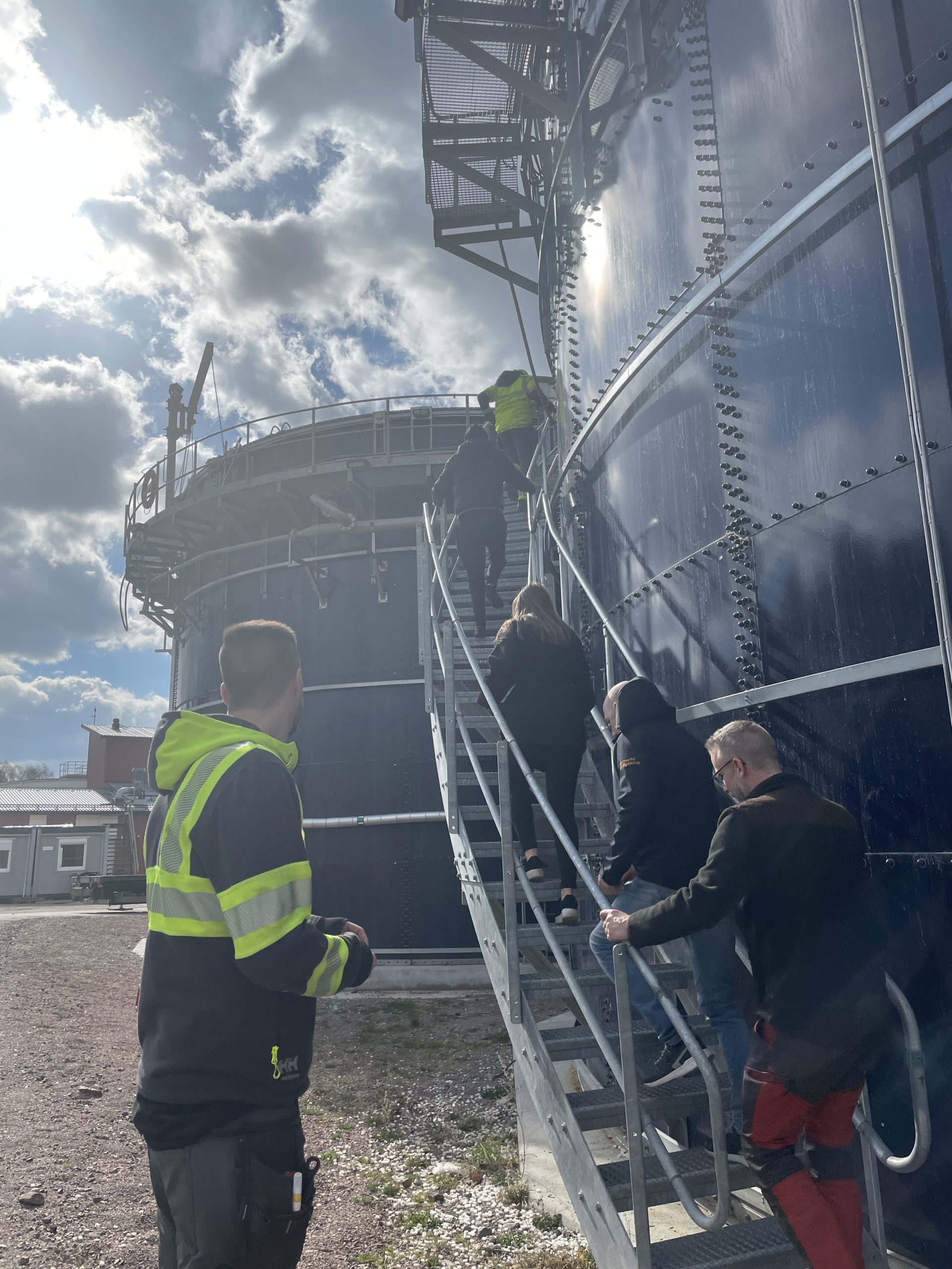 En grupp människor på väg uppför en trappa till en silo på reningsverket.