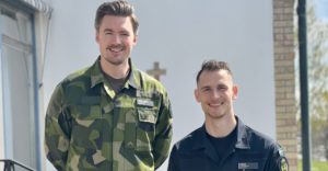 Två uniformsklädda personer, en i grön uniform och den andra i blå.