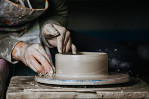 Keramikkurs: Två händer som formar en keramikskål på en drejskiva