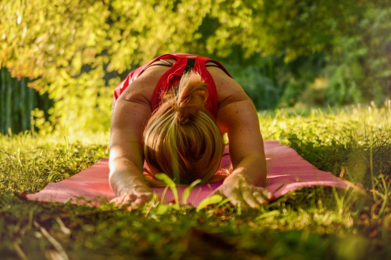 En kvinna som uttövar yoga utomhus