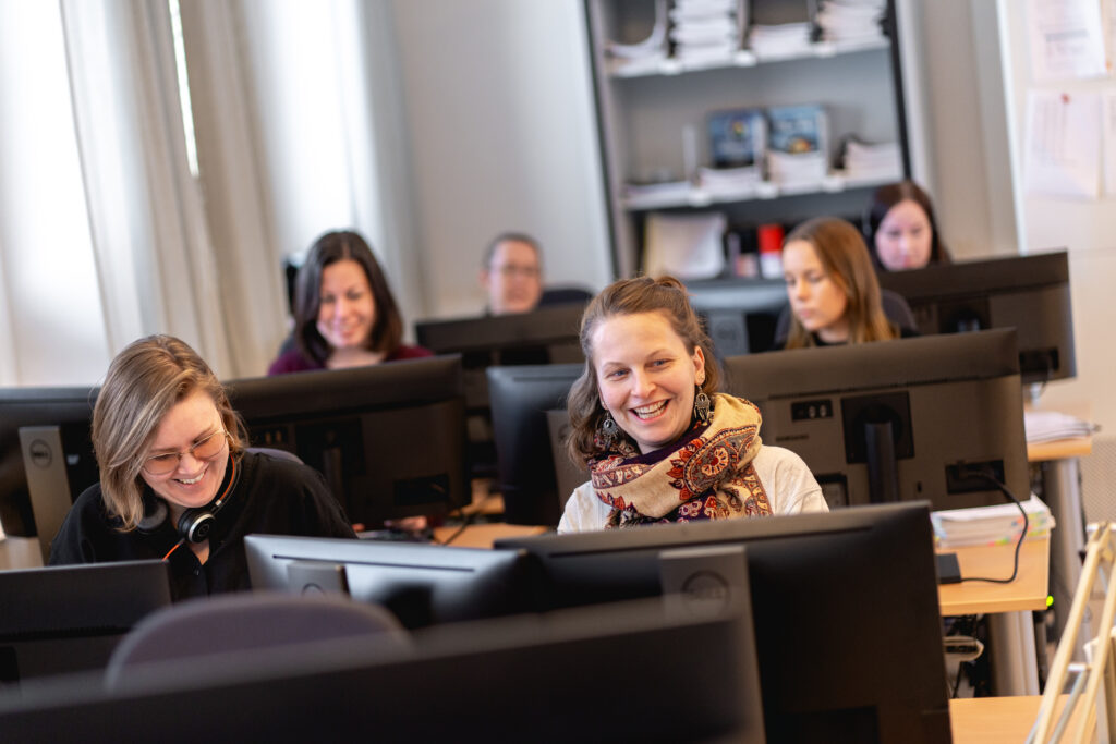 Sex personer som sitter vid varsin dator i en datasal.