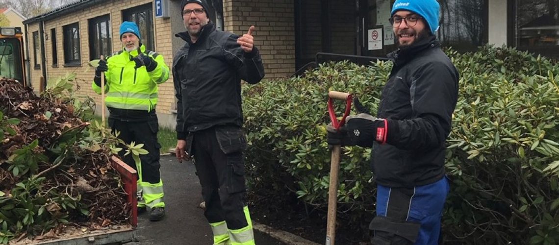 Deltagare som gör tummen upp när de jobbar ute med att klippa ner utomhusväxter.