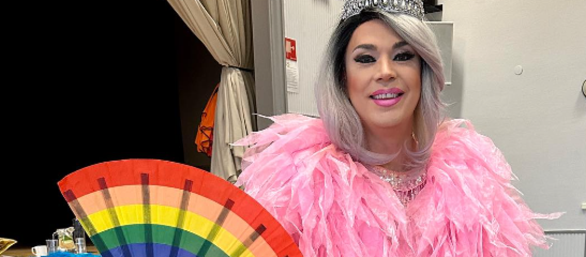 Tant Henrik från Bland drakar och dragqueens håller en regnbågsmönstrad solfjäder
